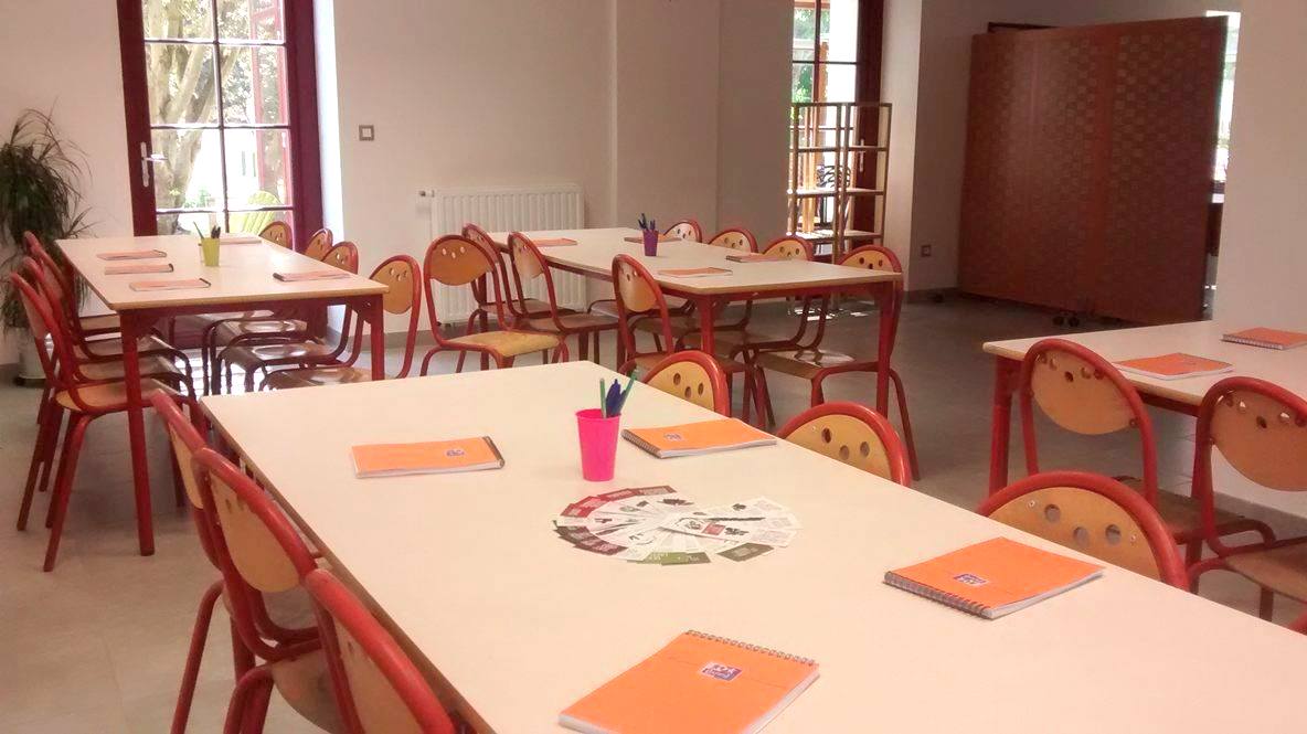 Salon, avec disposition des tables pour une classe découverte